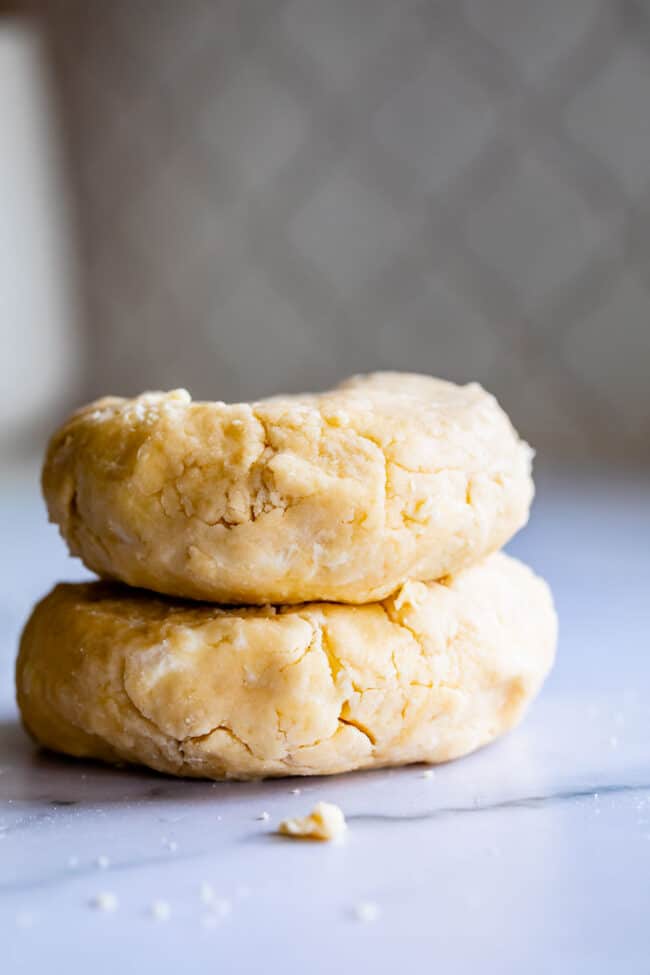 two rounds of flaky pie crust stacked shot from the side.