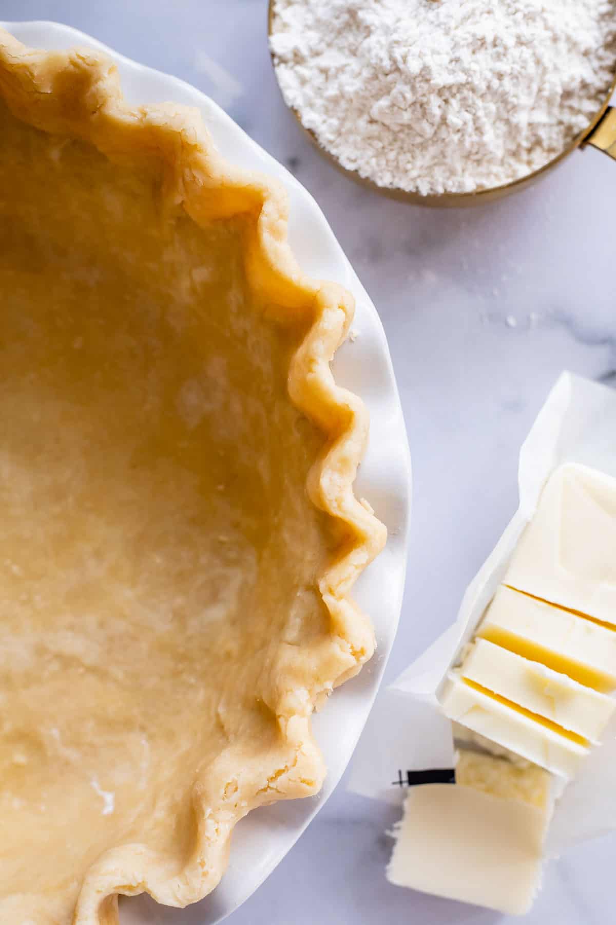 overhead shot of fluted raw pie crust in a pan