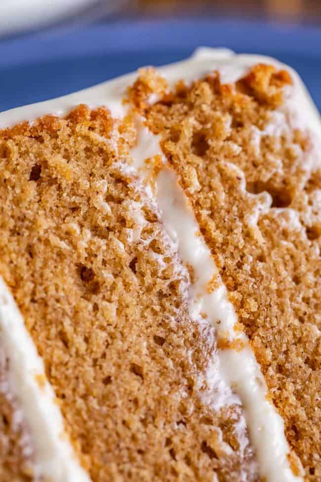 spice cake slice on a plate frosted with cream cheese frosting.