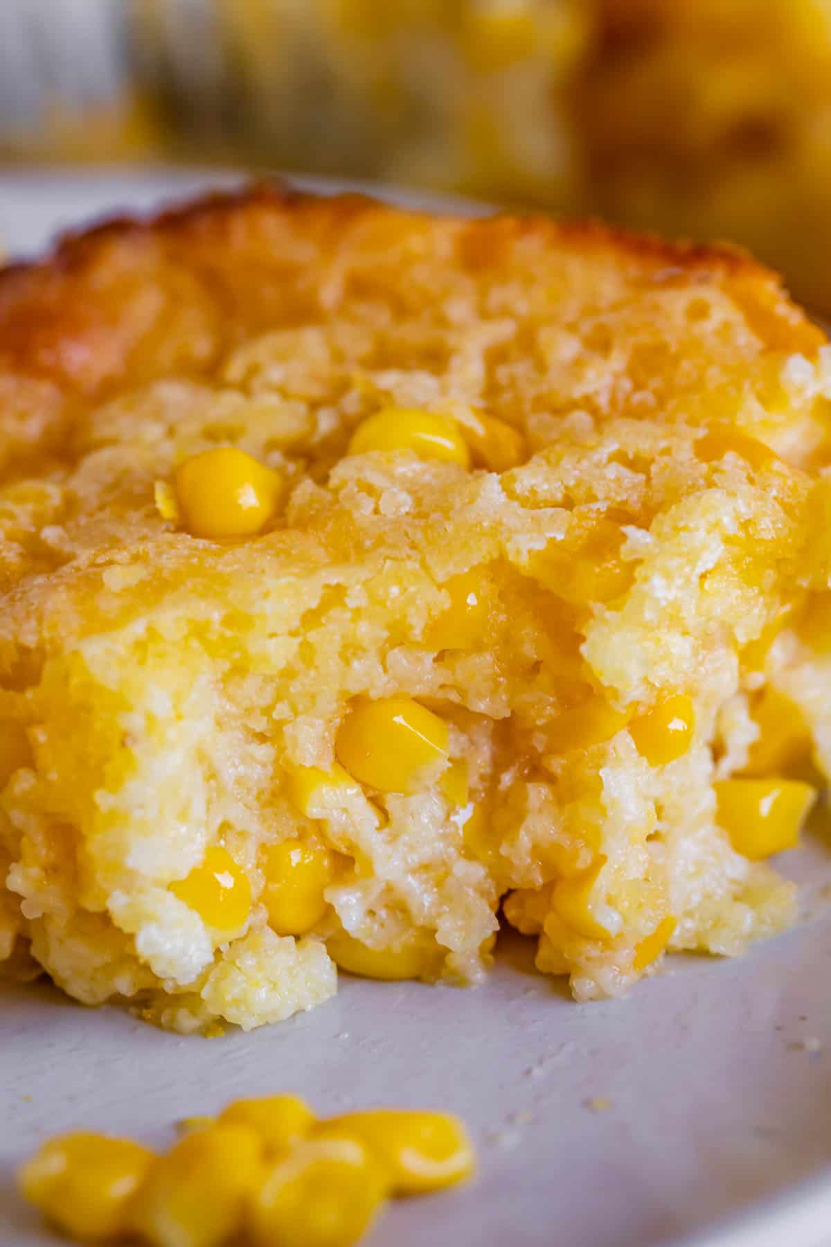 creamed corn casserole on a plate with a bite taken out