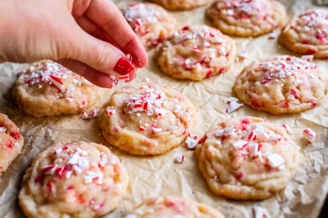 sprinkling crushed candy canes on top of sugar cookies.