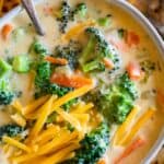 quick broccoli cheese soup in a white bowl with cheese on top and a silver spoon