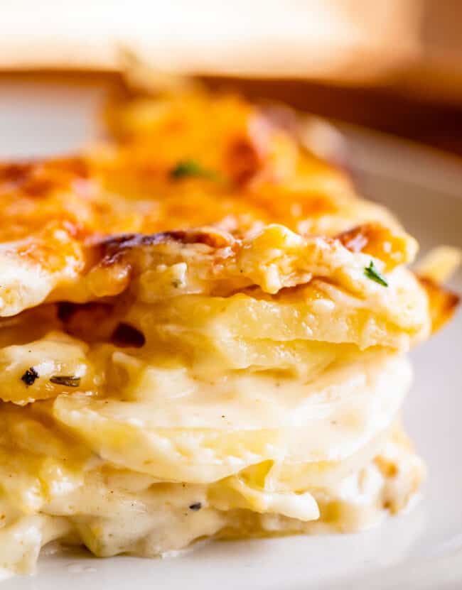 cheesy scalloped potatoes stacked on a plate.