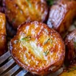 roasted red skin potatoes on a fork sprinkled with herbs