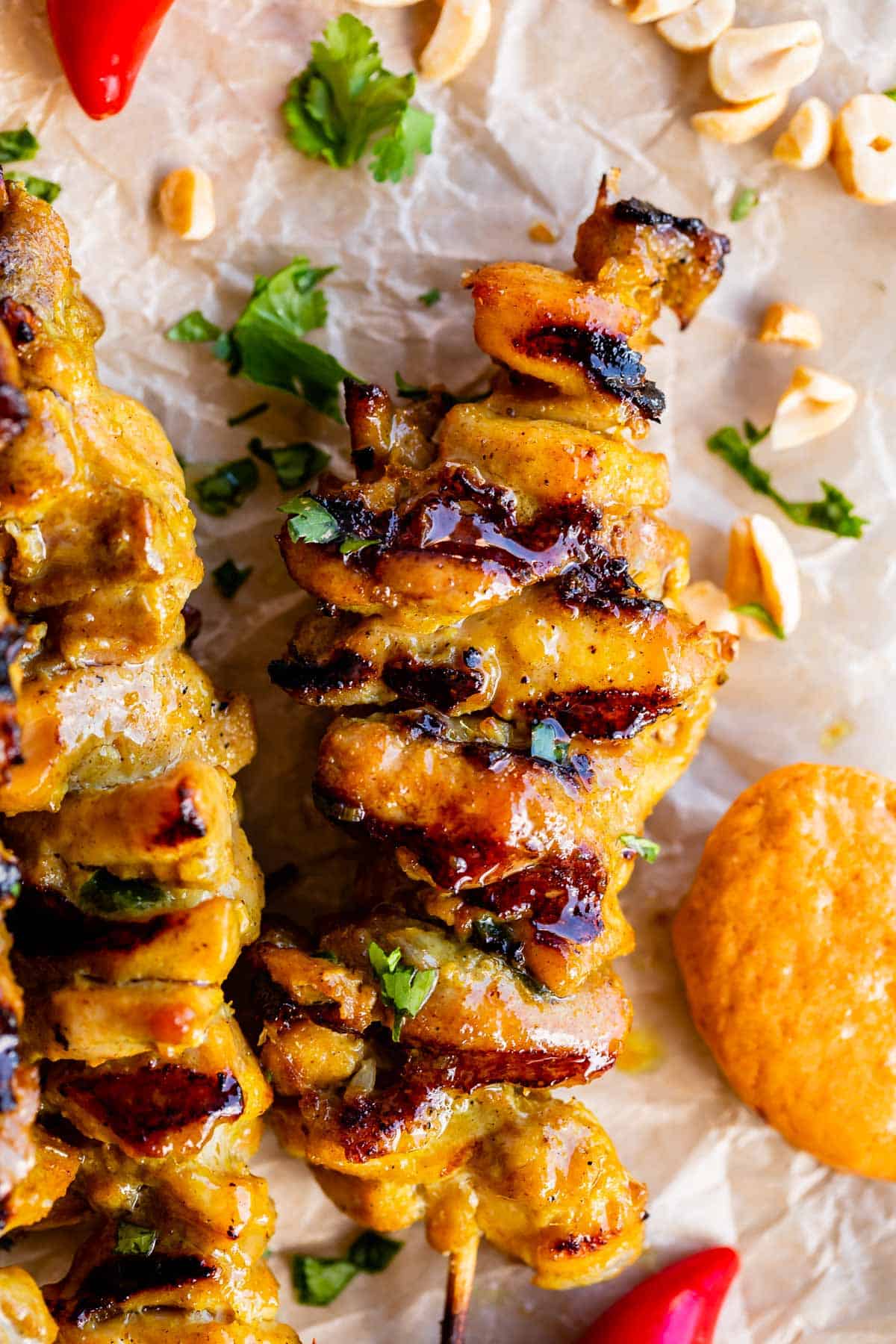 thai chicken satay on a skewer with peanut sauce on the side