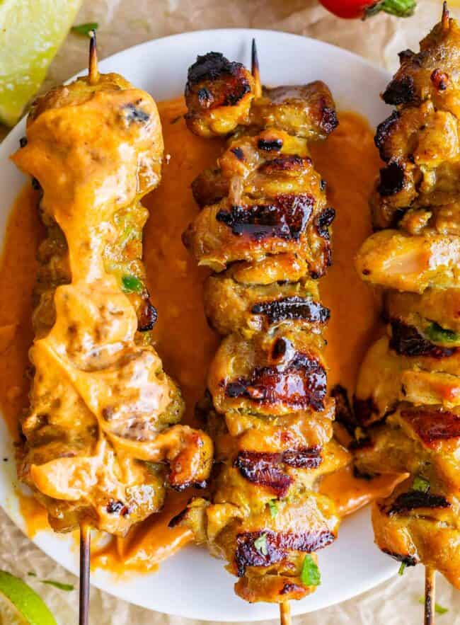 chicken satay recipe with one dipped in peanut sauce.