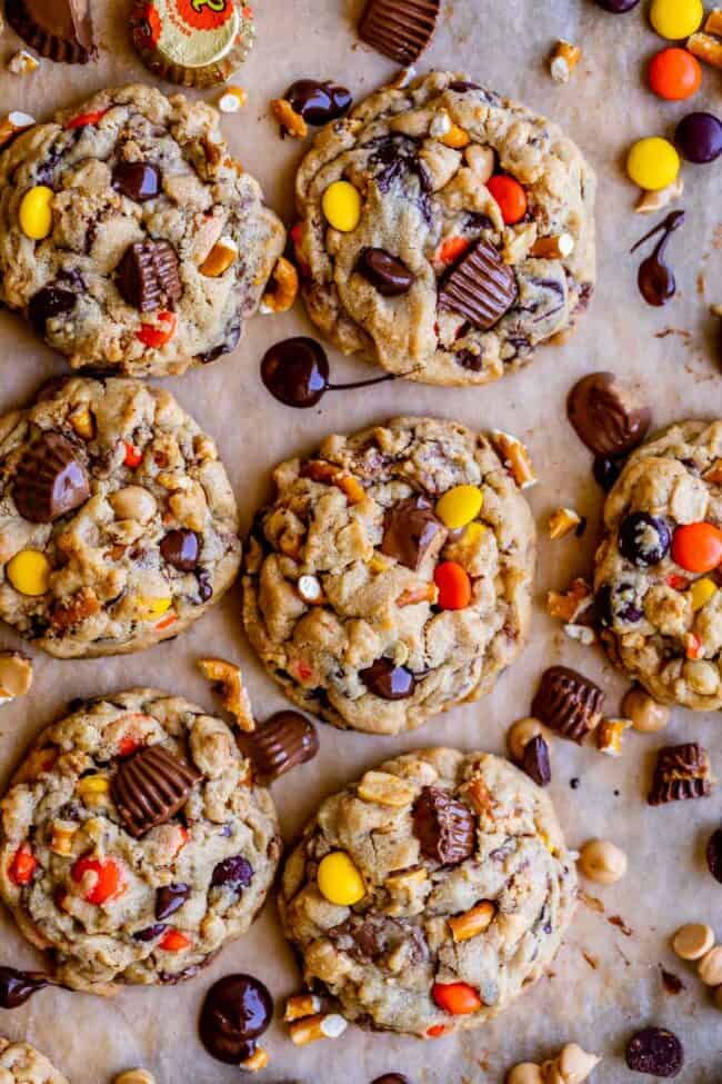 Reese's peanut butter cookies with tons of mix-ins on a sheet pan from overhead.