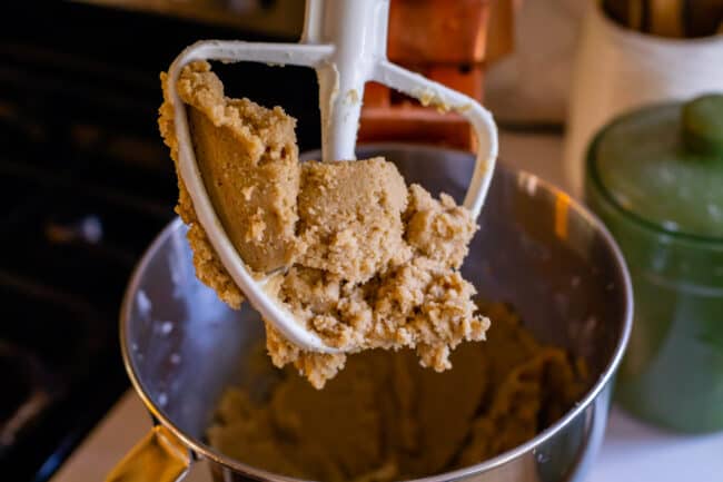 butter and sugar mixed together on the paddle of a stand mixer.