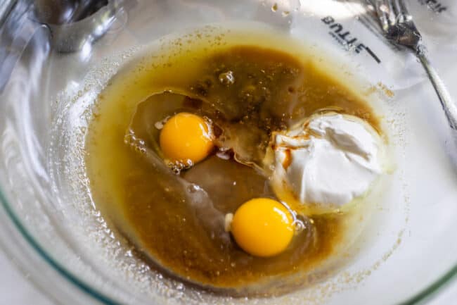 A glass bowl with wet ingredients for quick bread.