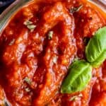 best pizza sauce in a mason jar with basil and oregano garnish