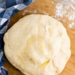 easy pizza dough recipe in a glass bowl with blue napkin