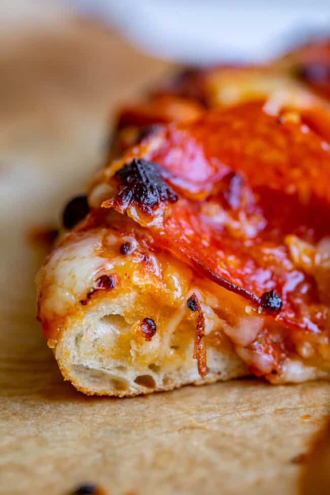 close up shot of pepperoni pizza on parchment paper.