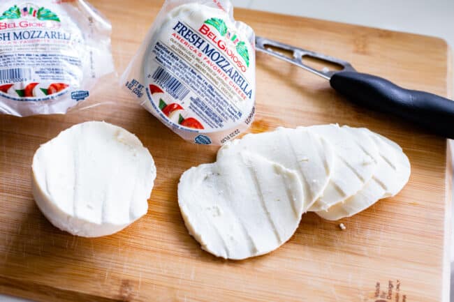 sliced fresh mozzarella cheese on a cutting board