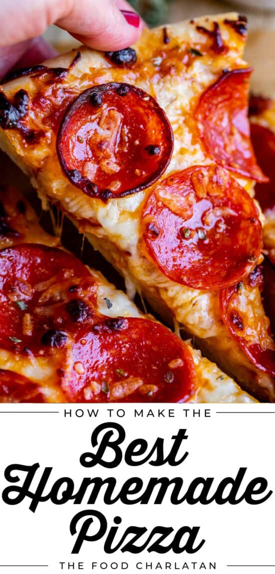 homemade pizza with pepperoni being lifted by hand