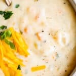 homemade potato soup in a white bowl with cheese garnish