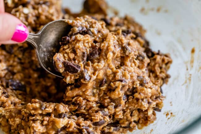 raw oatmeal chocolate cookies dough with a spoon.