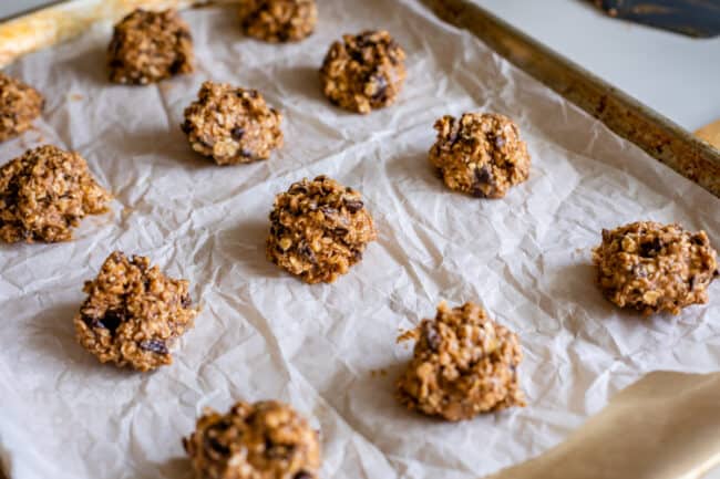 cookie dough balls lined up on pan ready to bake.