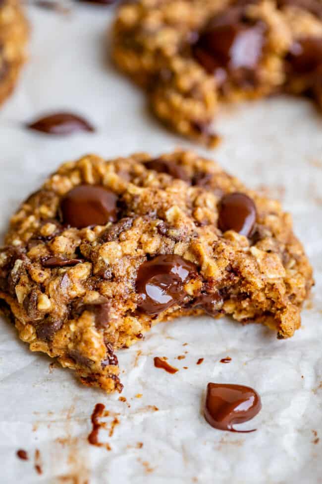 oatmeal chocolate chip cookies on a sheet pan with bite taken out.