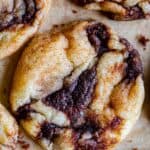 soft cinnamon roll cookies with cinnamon swirl on parchment paper
