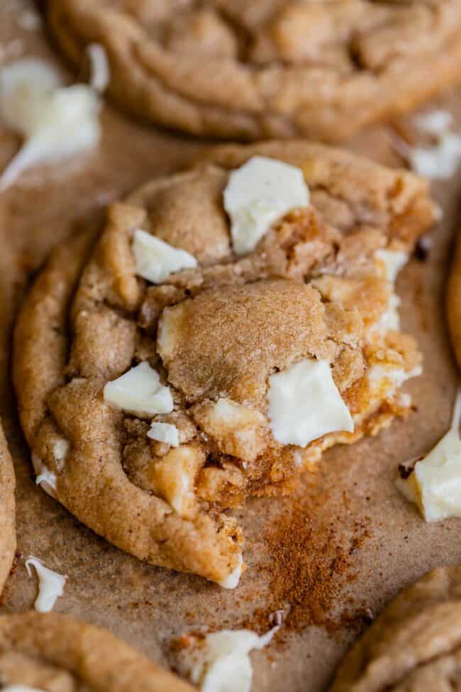 half of a white chocolate cookie on a pan with cinnamon sprinkled