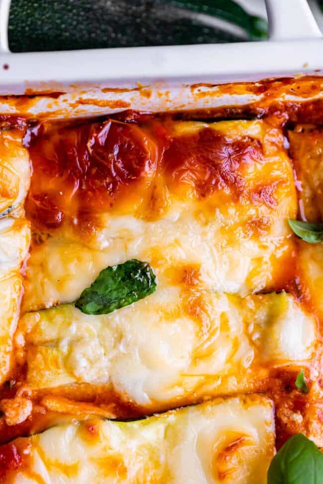 zucchini noodle lasagna in a white pan with basil.