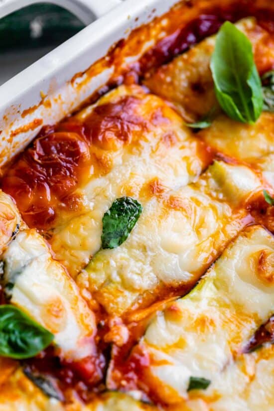keto zucchini lasagna in a casserole dish topped with basil
