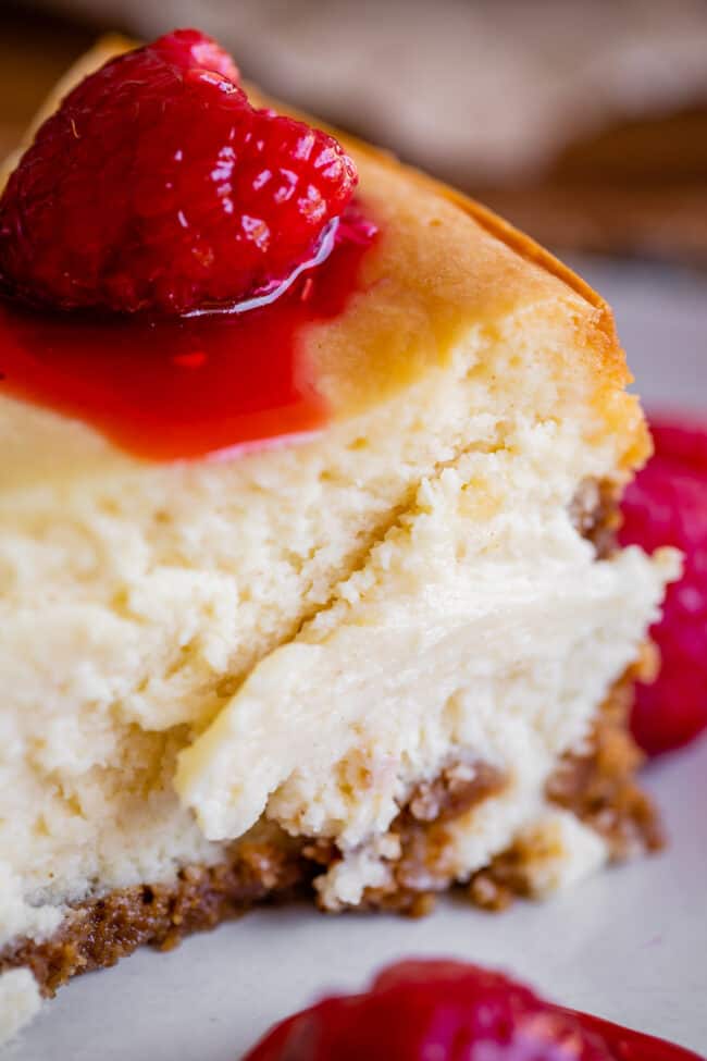 classic cheesecake recipe with raspberries on a plate.