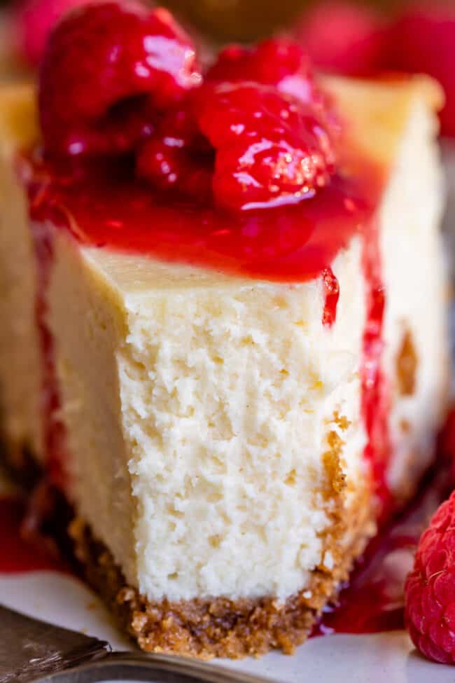best cheesecake with a bite taken from the front with raspberries.