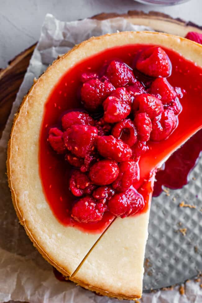 overhead shot of classic cheesecake recipe with raspberry sauce on top.