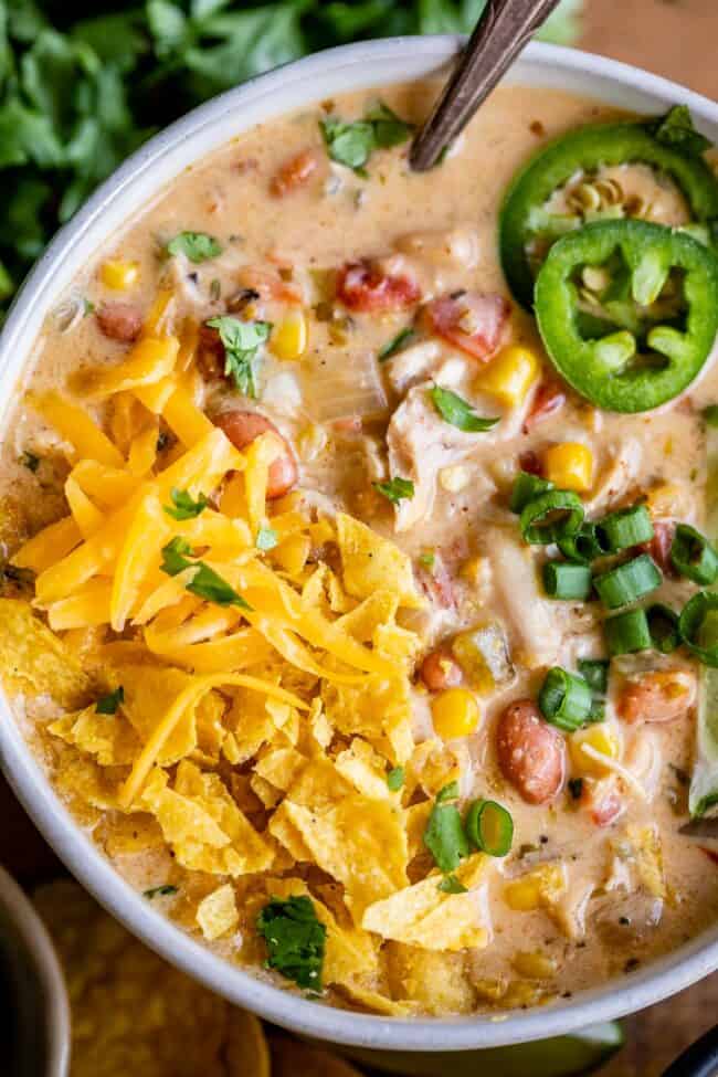 white bean chicken chili with cheese and tortilla chip garnish.