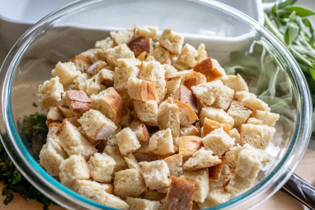 cubed toasted bread in a large glass bowl