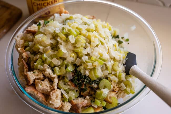 sauteed celery and onions on top of a bowl of cubed bread