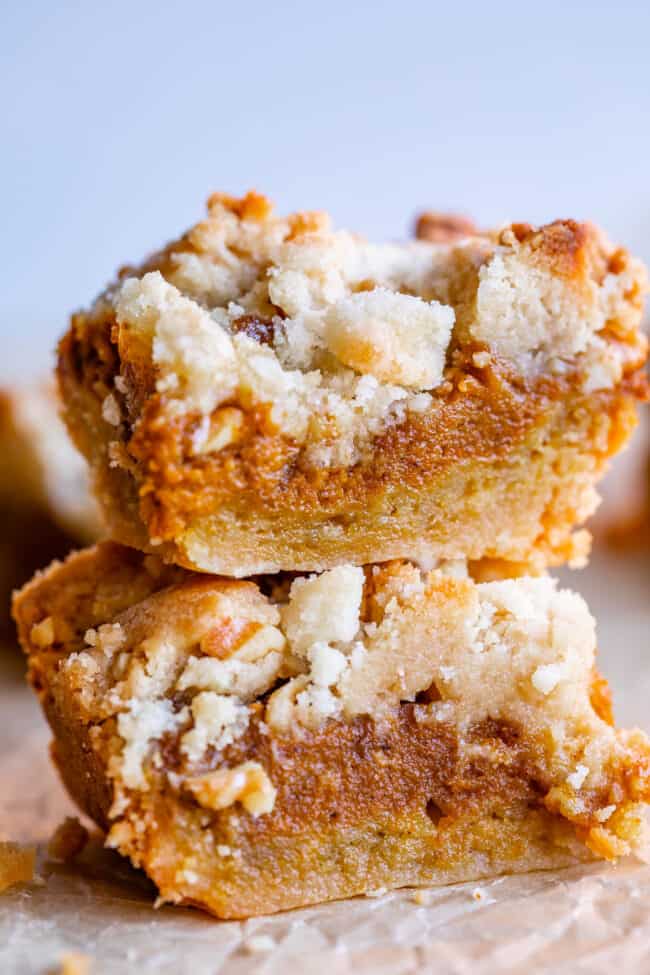 pumpkin pie bars with shortbread crust stacked on top of each other