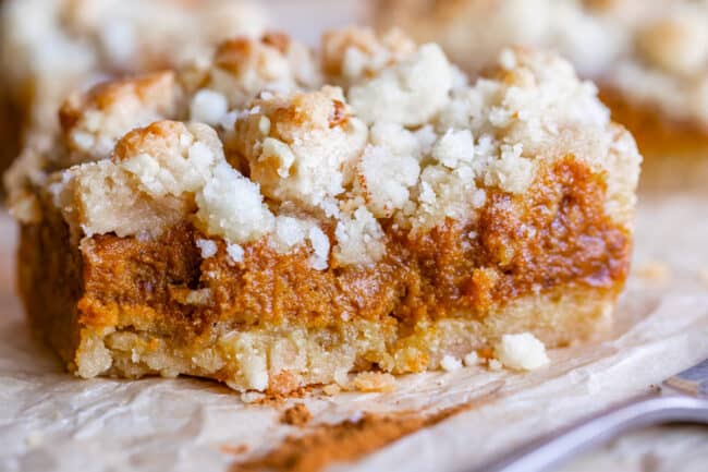square of pumpkin pie bar on parchment paper with fork