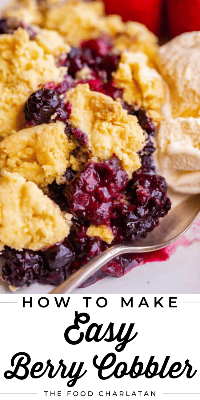 berry cobbler on a white plate with vanilla ice cream and a spoon.