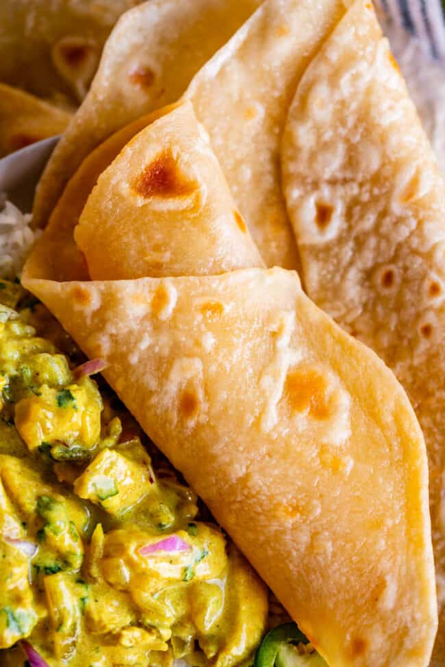 rolled indian flatbread on a plate with yellow curry.