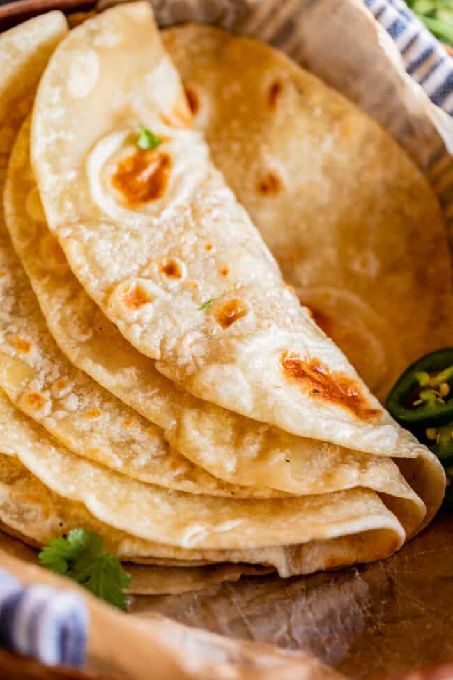 soft roti recipe folded over in parchment paper with cilantro.