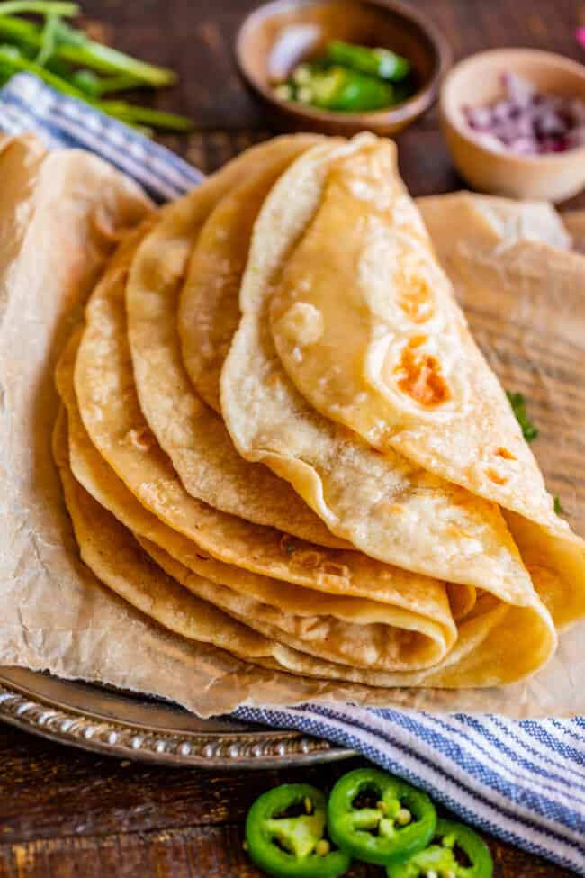 Indian roti bread on a metal plate with blue napkin and parchment paper.