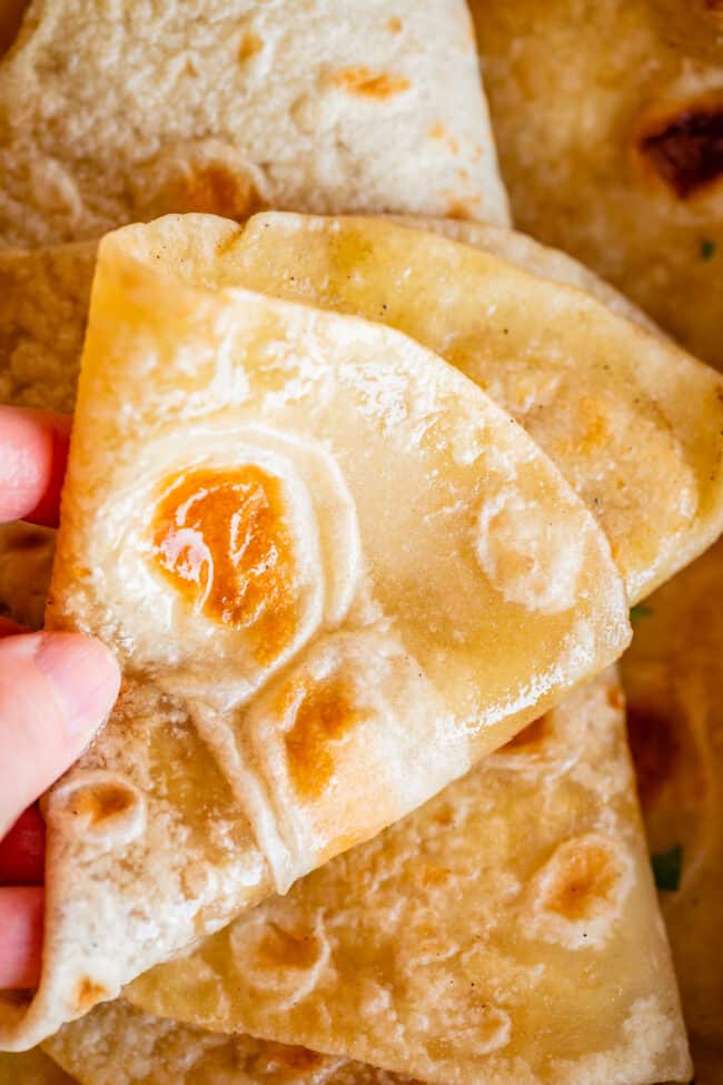 hand moving roti Indian bread to show softness.