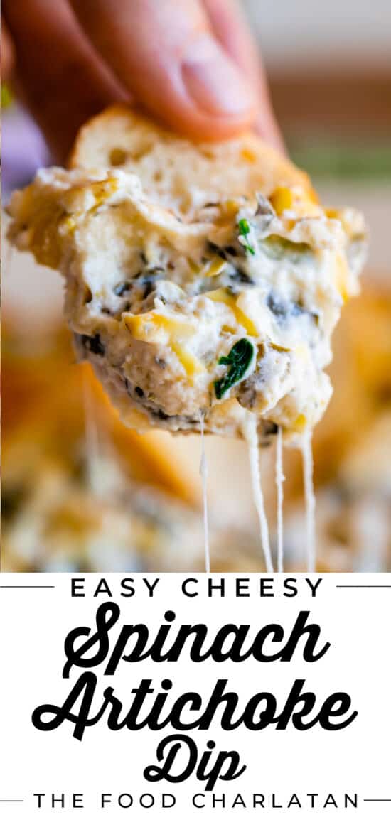 hand holding a piece of toast dipped in easy spinach artichoke dip