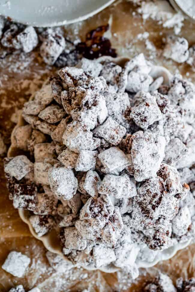 chex mix muddy buddies shot from overhead on a scalloped edge plate.