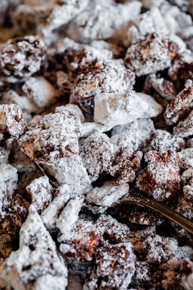 a spoon lifting up chex mix muddy buddies.