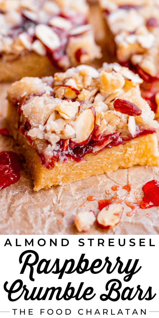 raspberry crumble bars with almond streusel on parchment paper.