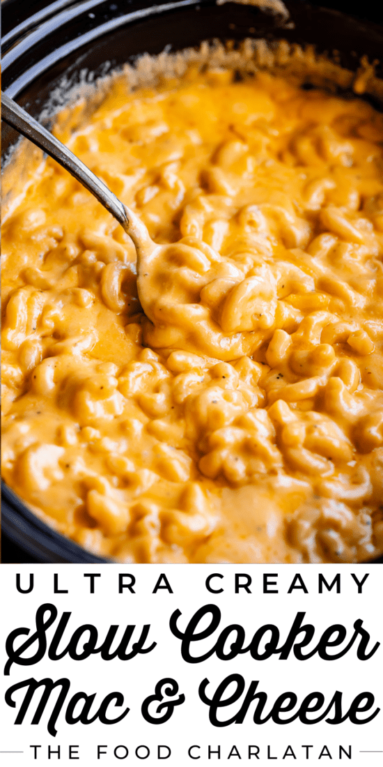 spoon lifting mac and cheese from a black crock pot.