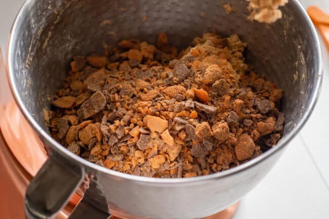bowl of peanut butter cookie dough topped with butterfinger baking bits