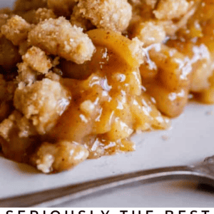 A close-up of a slice of Dutch apple pie with a crumbly streusel topping, gooey apple filling, and flaky crust on a white plate. Text reads: Seriously Delicious Dutch Apple Pie. The Food Charlatan.