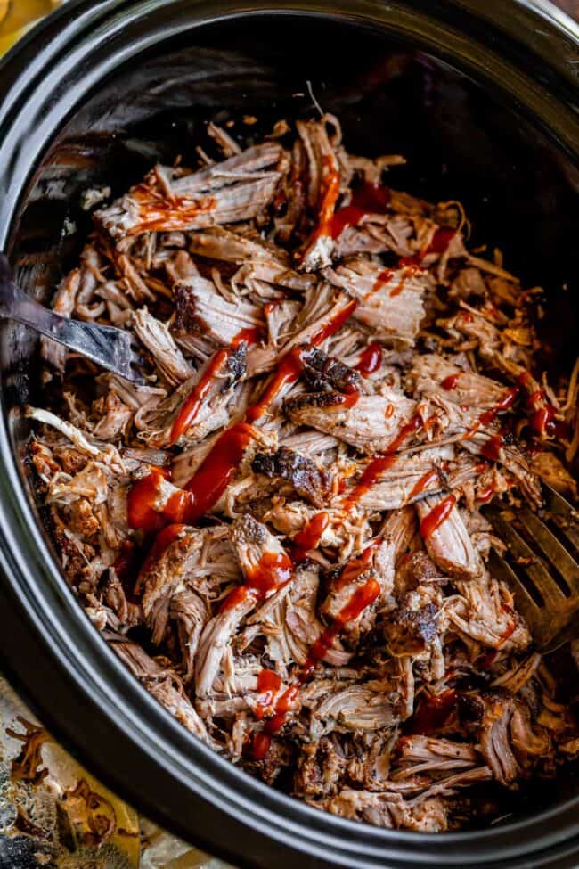 crock pot pulled pork shredded in a black crock pot.