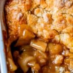 overhead shot of easy apple cobbler in a white dish, with some topping removed.