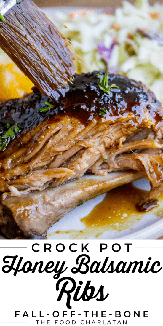 ribs made in the crock pot, on a plate with coleslaw, being brushed with glaze.