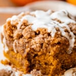 pumpkin spice coffee cake with drizzled glaze on a white plate.